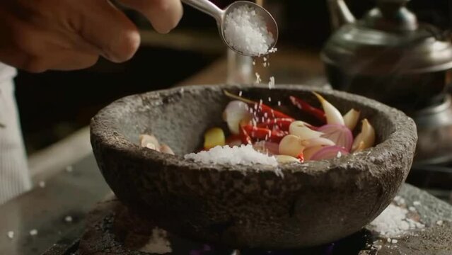 pouring a spoon of salt to a bowl