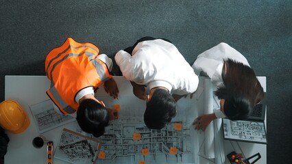 Top down view of project manager and civil engineer hold laptop while explain idea to architect....