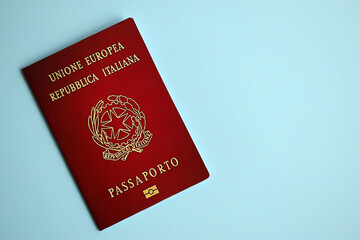 Italian passport on blue background close up. Tourism and citizenship concept