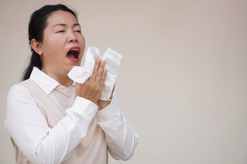 Asian woman is sneezing, open mouth, holds white tissue paper. Concept, Health problems. Ill, sick...