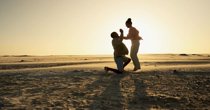 Happy couple, beach and sunset proposal with yes, excited and jump for date, romance and celebration on valentines day. Excited woman and man hug and kiss by ocean for engagement, love and success