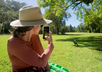 Girl takes a happy photo with her cell phone on a picnic.