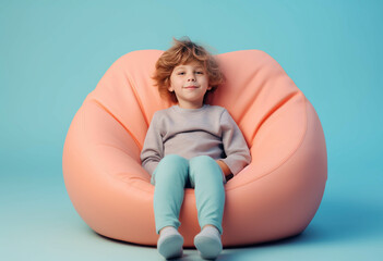 Happy children's day, happy boy smile is sitting on a bean bag isolated