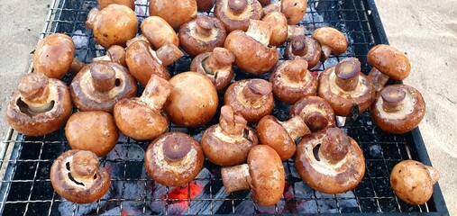 Grill mushrooms. Cook food on the grill. Frying champignon mushrooms. Grilled champignons. Picnic, outdoor recreation.