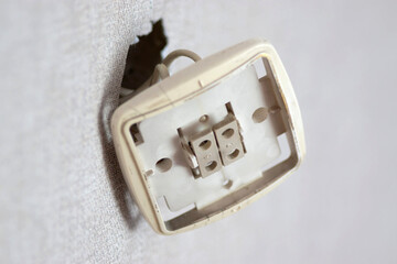 Exposed Electrical Socket With Missing Cover on a White Wall
