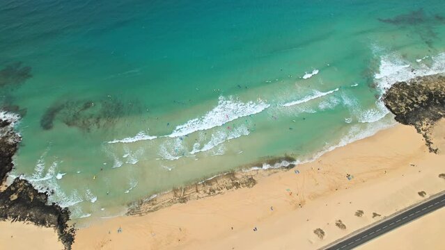 Overhead aerial view of surfers on Alzada beach in Corralejo Park, Fuerteventura island, Spain