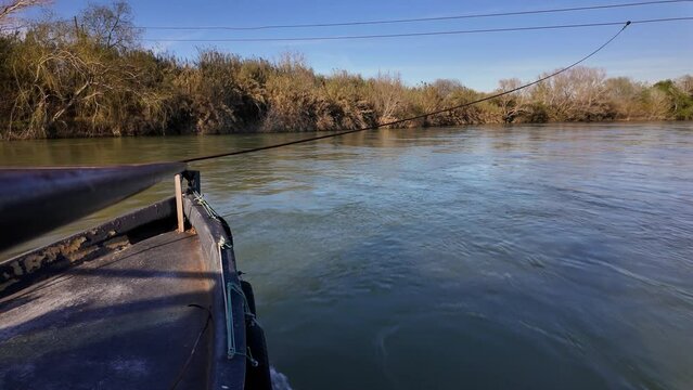 Traditional car ferry crossing the majestic Ebro River in Miravet. Is the last river ferry that allows crossing the Ebro River, consisting of two llaguts connected by a platform that can accommodate