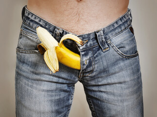 Banana sticking out of the fly of a man's jeans