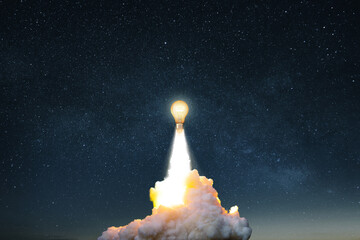 Creative burning light bulb rocket with blast and clouds of smoke successfully takes off into the...