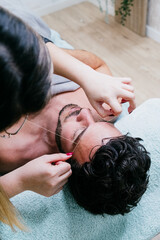 Vertical picture of male eyebrow waxing threading