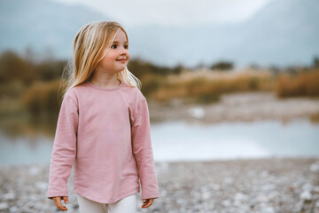 Cute girl 4 years old child walking outdoor happy smiling portrait family travel lifestyle summer vacations lake and mountains nature