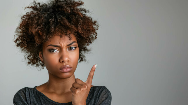 Angry Black Woman Making A Disapproving Gesture With Her Finger. Conveying a Sense of Disagreement or Refusal