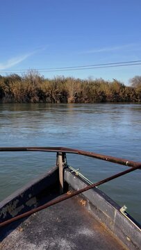 Traditional car ferry crossing the majestic Ebro River in Miravet. Is the last river ferry that allows crossing the Ebro River, consisting of two llaguts connected by a platform that can accommodate