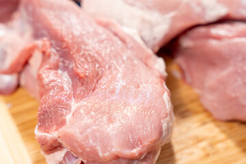 Pork meat cut into pieces lies on a cutting board. Pork meat close-up.