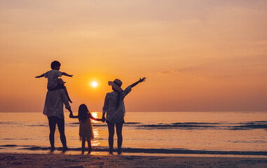 together, sun, sunset, sunrise, relaxation, parent, freedom, silhouette, son, beach. A family is standing on the beach, with the sun setting in the background. children are holding hands with parents.