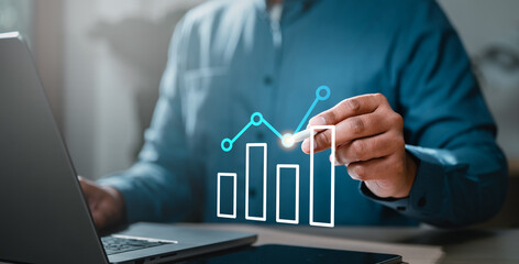 achievement, chart, diagram, graph, increase, leadership, management, marketing, performance, plan. A man is drawing a graph on a laptop. The graph is a line graph. Concept of data visualization.
