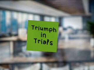 Post note on glass with 'Triumph in Trials'.
