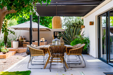 Chairs and table arranged in patio outside house.