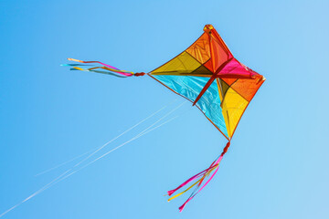 A colorful kite is flying high in the sky