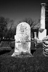 An old stone tombstone with a blank epithet in black and white.