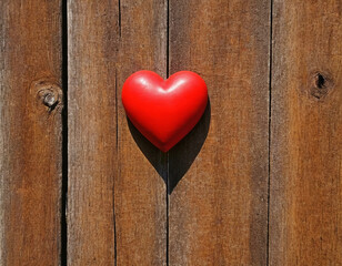 Bright red heart as a symbol of love and friendship on the background of a wooden wall or fence
