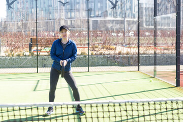 Obraz premium woman playing paddle tennis outdoors.