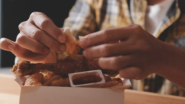 close up focus woman hand hold fried chicken for eat,girl with fast food concept