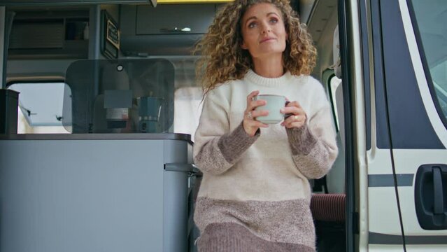 Tranquil tourist sitting campsite stairs with tea cup close up. Woman drinking