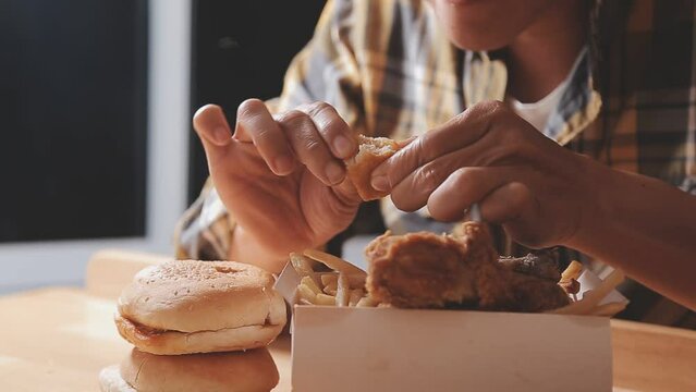 close up focus woman hand hold fried chicken for eat,girl with fast food concept