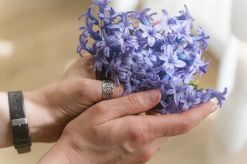 A bouquet of field blue flowers in the hands of a girl. Mouse hyacinth.
