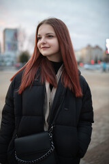 Obraz premium Portrait of a young red-haired girl outdoors in spring.