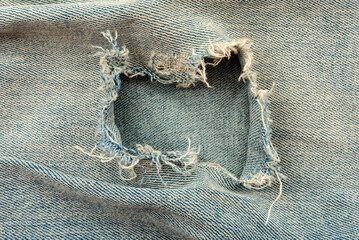 Hole in denim fabric. Ripped jeans