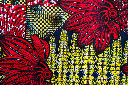 top view of red yellow ankara fabric, flatlay of nigerian wax cloth with designs, spread out red yellow ankara material