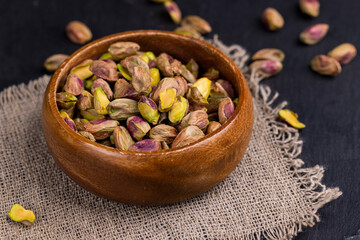 peeled pistachios in a wooden bowl, close-up