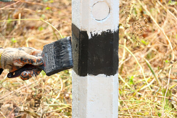The black-and-white navigation roadside pillars are being repainted to make them more visible. Rural road officials are rushing to paint road pillars during the summer in rural Thailand.