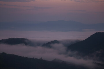 Background image of a morning landscape on a mountaintop with mountains and a sea of ​​mist before the sun rises. There is space for text.