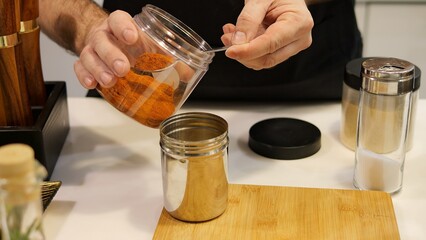 The chef carefully mixes seasonings to cook the meat, ensuring that each seasoning enhances its flavor. It combines seasonings with precision, creating the perfect balance for cooking.