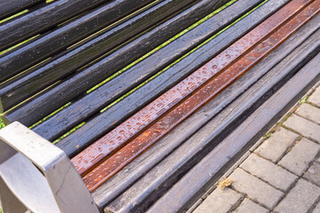 Bench in a park with rain drops - close-up