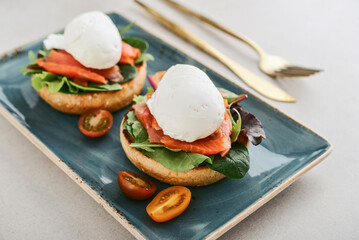 Eggs Benedict with salad leafs, salmon and fresh cherry tomato - 771491704