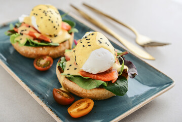 Eggs Benedict with salad leafs, salmon and fresh cherry tomato - 771491712