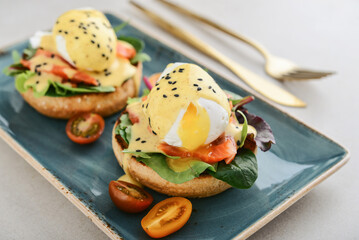 Eggs Benedict with salad leafs, salmon and fresh cherry tomato - 771491720