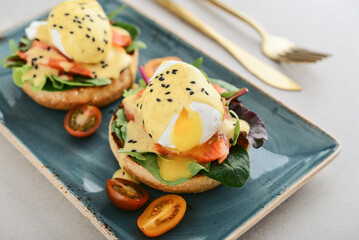 Eggs Benedict with salad leafs, salmon and fresh cherry tomato - 771491734