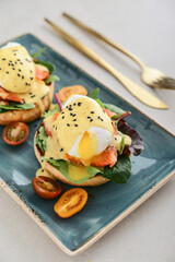 Eggs Benedict with salad leafs, salmon and fresh cherry tomato - 771491759