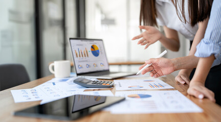 Business woman meeting to discuss the situation on the market, using laptop and graph chart.