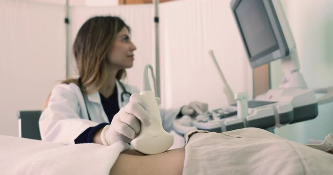 Hispanic female gastroenterologist or general surgeon examining abdominal area of young woman patient using convex probe and ultrasonography equipment. Preventive medicine, check-up and health-care