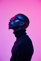 Young african american man in sunglasses and black sweater isolated on pink background.
