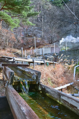 木製の樋を流れる温泉水