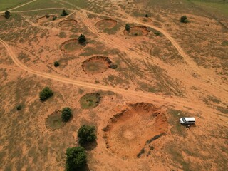 Aerial view of bomb craters on a dry field in Laos