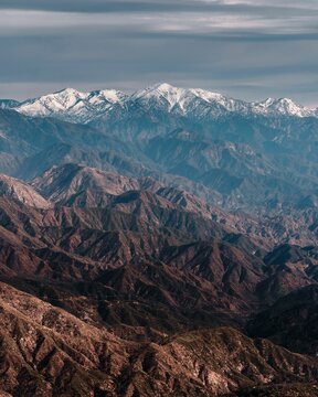 the top of mountains, covered in snow and dust, with a few white clouds: San Gabriel Mountain