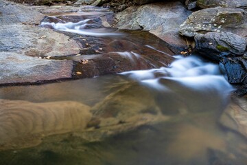 Crystal-clear stream of water cascades over a rocky ledge